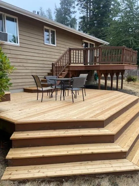 New cedar deck seen from the yard, upper deck and stairs behind it