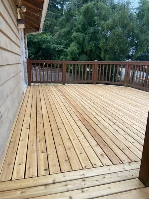 The deck along the wall of the house, boards running away from the camera