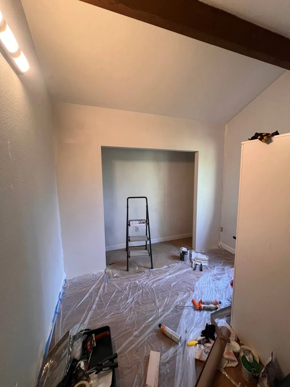 The finished closet alcove painted white, step ladder inside