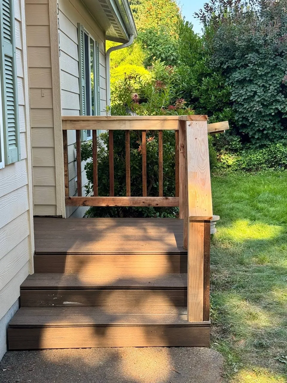 The rebuilt front steps and landing with a new wooden railing